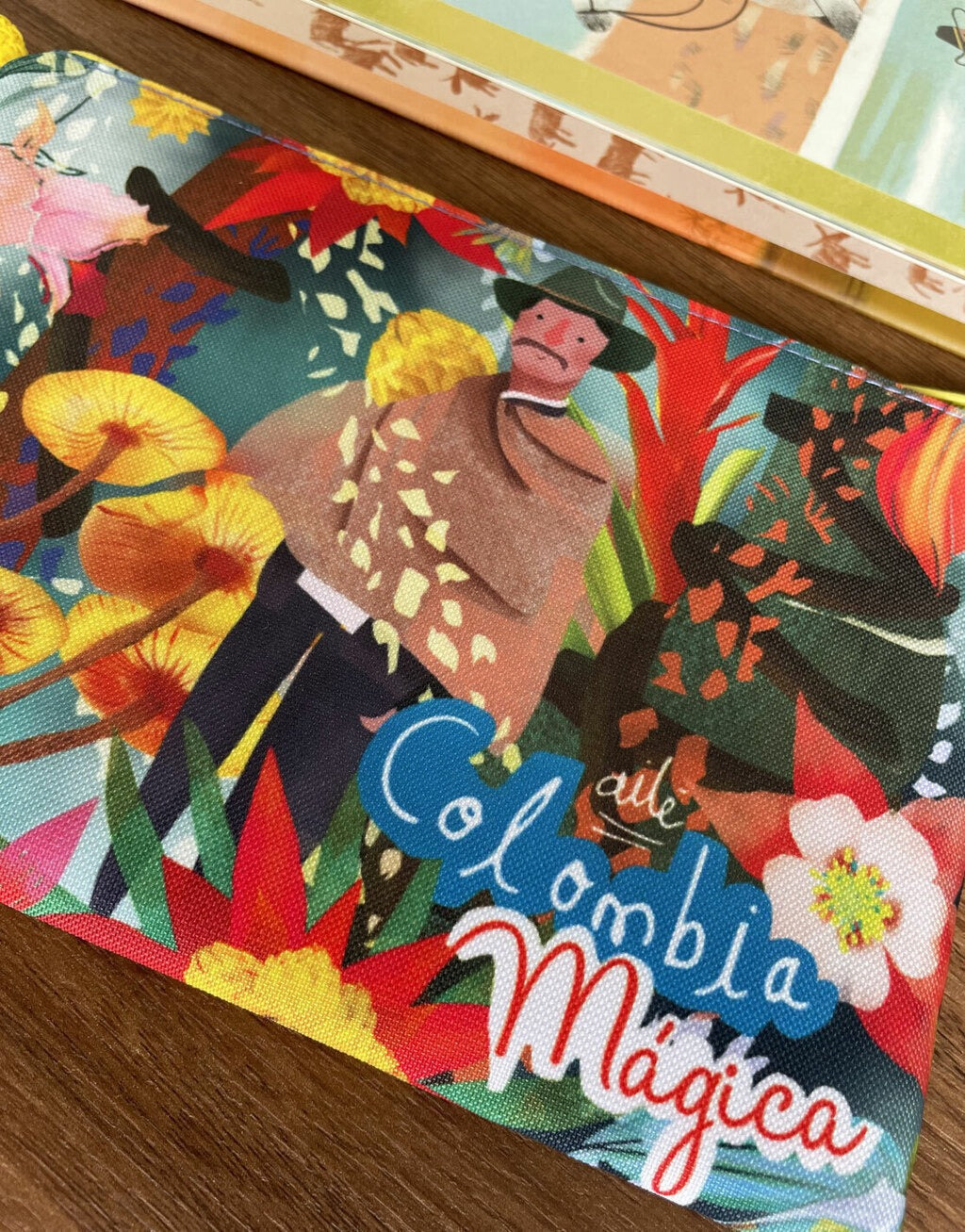 Detalle de cosmetiquera grande o pequeña "Colombia Mágica" — campesino colombiano con sombrero y ruana, naturaleza, fauna, biodiversidad colombiana entre flora tropical, diseño - regalo para extranjeros, recuerdo de viaje original. hecho en Colombia. Ailé