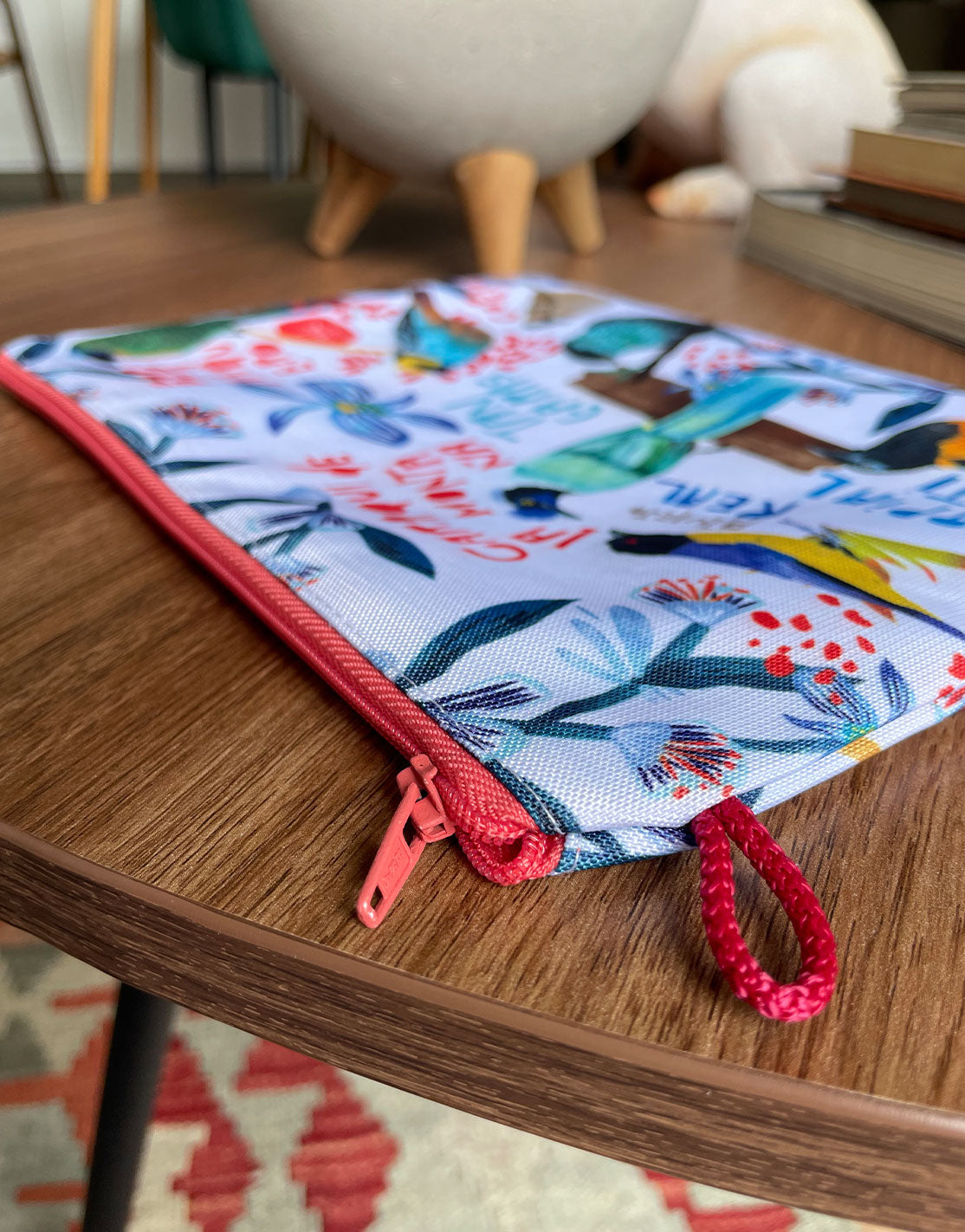 Cosmetiquera de diseño colombiano con cremallera roja — detalle de acabado e ilustración de aves, regalo sostenible, recuerdo de viaje original, hecho en Colombia. Ailé