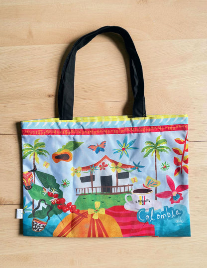 Tote bag ilustrada Colombia con diseño de paisaje cafetero, tote bag Colombia diseño original, bolso tela paisaje cafetero, tote bag ilustrada souvenir Colombia, bolsa Colombia asas negras, ilustración casa cafetera Colombia, tote bag café colombiano, diseño tropical colombiano bolso, comprar tote bag Colombia online, souvenir colombiano tienda online.Ailé.