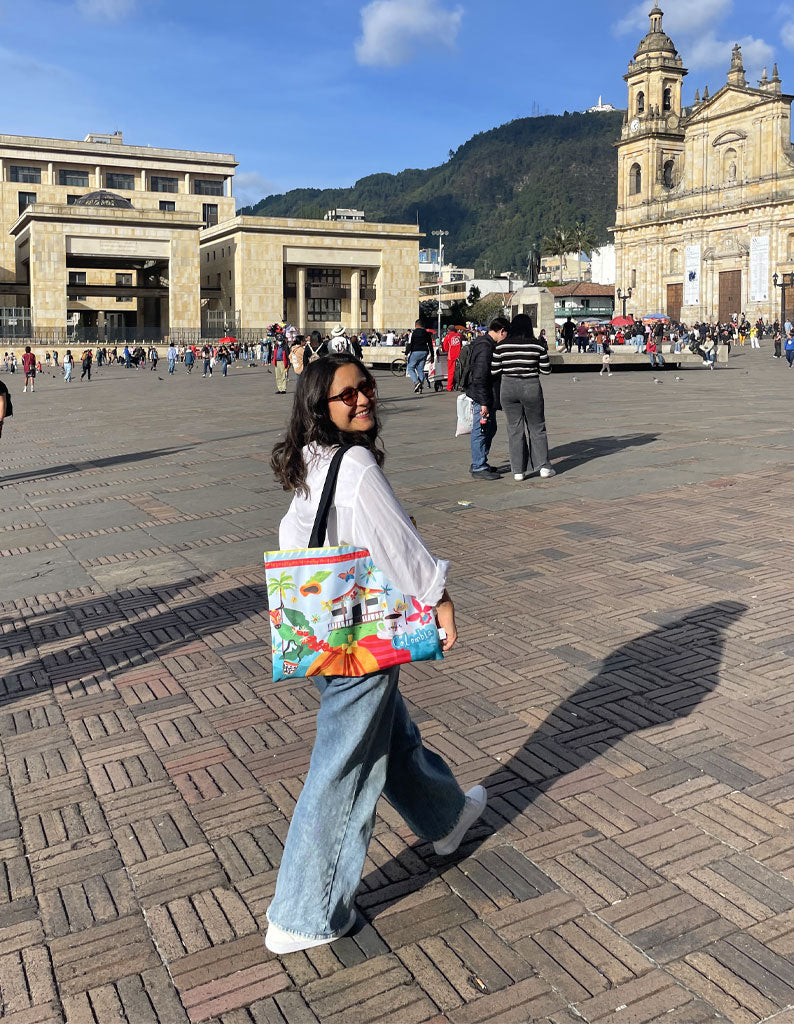 Mujer con tote bag ilustrada Colombia en la Plaza de Bolívar, Bogotá, Plaza de Bolívar Bogotá, souvenir Plaza de Bolívar, tote bag centro histórico Bogotá, 
recuerdo Bogotá centro, souvenir turístico Colombia, bolso recuerdo de viaje Colombia, tote bag ilustrada viaje a Bogotá, Bogotá Colombia souvenir bag
Plaza de Bolivar gift, authentic Colombian travel bag.Ailé.