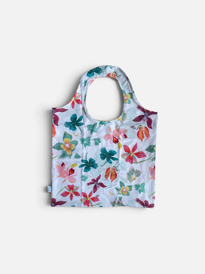 bolsa ecológica flores acuarela Colombia, tote bag plegable estampado floral blanco, bolsa de tela orquídeas para el mercado, bolsa para ir al mercado reutilizable, bolsa plegable para el bolso diario, accesorio sostenible uso diario mujer, regalo ecológico para ella, detalle sostenible mujer amante de las flores, regalo consciente botánico Colombia, foldable eco bag orchid print, reusable market bag Colombia, sustainable tote recycled bottles floral, bolsa plegable Ailé orquídeas. Ailé
