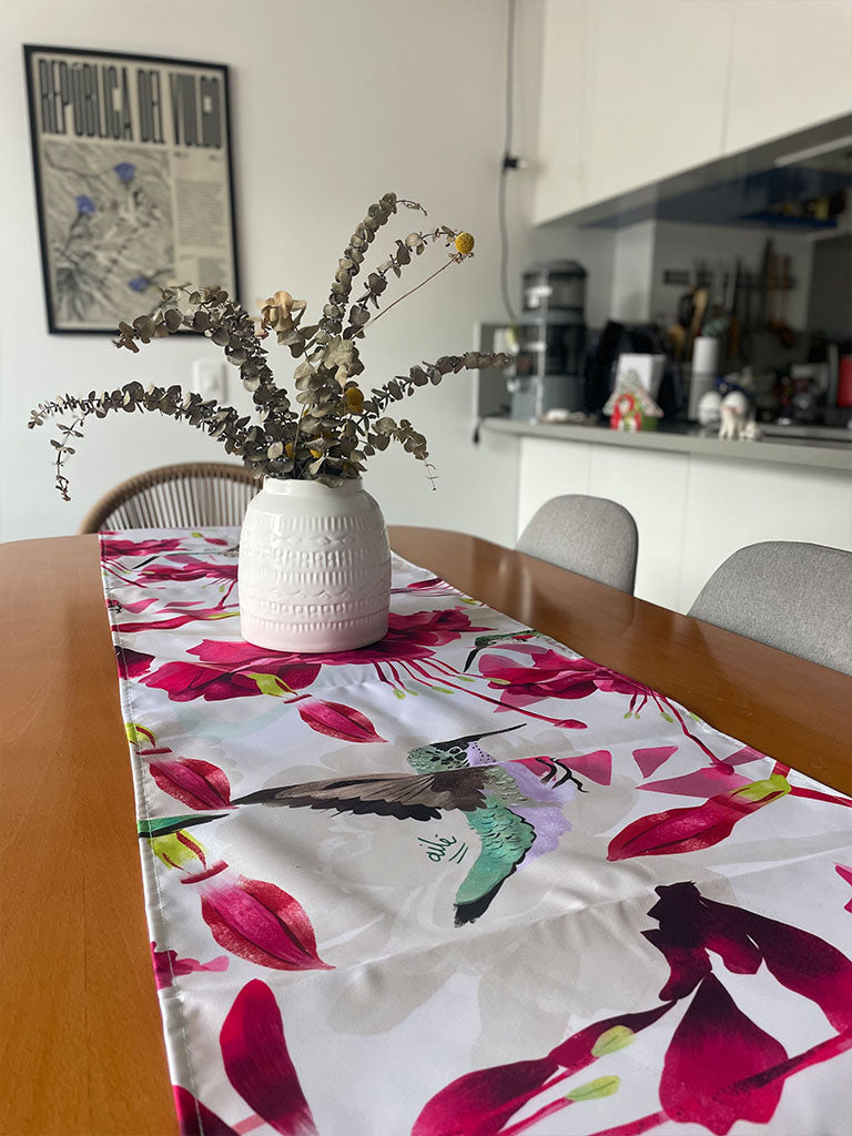 Decoración en mesa de comedor ilustrado con colibríes colombianos entre flores tropicales fucsia, egalo cultura colombiano, Colombian table runner illustrated, colombianos en el exterior y turistas, eco table runner Colombia, decoración colombiana para comedor, Colombian design table runner gift, recycled fabric table runner Colombia, hecho en Colombia, camino de mesa con diseño de fauna colombiana. Ailé