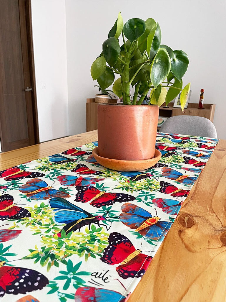 Camino sobre mesa de madera diseño mariposa monarca colombiana ilustrada, Colombia país de mayor diversidad de mariposas, souvenir colombiano, regalo para extranjeros, regalo mariposas colombianas, mariposas de Colombia, mariposa monarca colombiana, regalo típico colombiano, corredor de mesa, camino de mesa ecológico Colombia, camino de mesa tela reciclada Colombia, souvenir colombiano, recuerdo de viaje original, camino de mesa impermeable colombiano, idea de recuerdos de colombia para extranjeros, Ailé