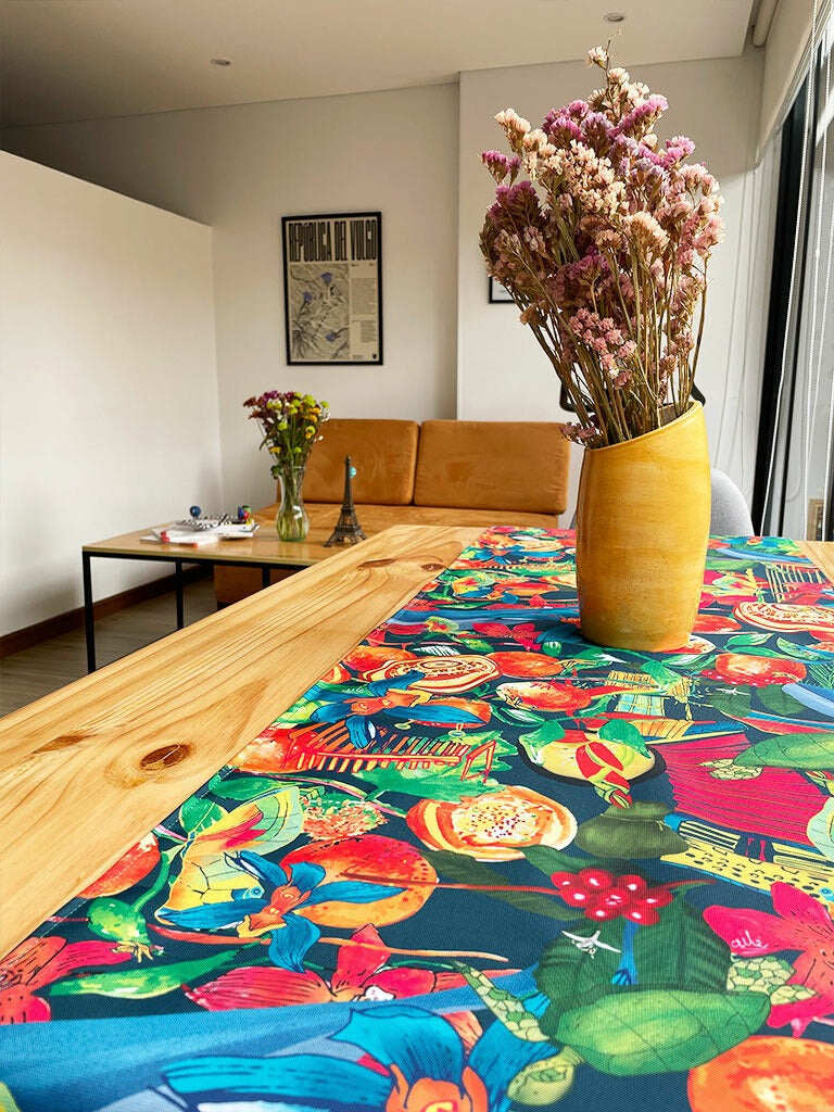 Camino sobre mesa de madera ilustrado Sabrosura con frutas tropicales, aves, flor de mayo, heliconias, cattleya, zona cafetera y pueblo colombiano, regalo colombiano sabor y cultura, vallenato colombiano, acordeón Colombia ilustrado, cultura caribe colombiana, corredor de mesa, camino de mesa ecológico Colombia, camino de mesa tela reciclada Colombia, souvenir colombiano, recuerdo de viaje original, camino de mesa impermeable colombiano, idea de recuerdos de colombia para extranjeros, centro de mesa. Ailé