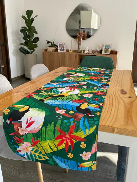 Decoración en mesa de comedor ilustrado con tucanes y flora tropical colombiana, heliconias y hojas de selva diseño original Ailé Colombia, estampado tropical colombiano, diseño selva Colombia regalo para extranjeros, Banda de mesa, camino de mesa fauna colombiana, regalo cultura colombiano, Colombian table runner illustrated, colombianos en el exterior y turistas, eco table runner Colombia. Ailé