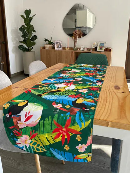 Decoración en mesa de comedor ilustrado con tucanes y flora tropical colombiana, heliconias y hojas de selva diseño original Ailé Colombia, estampado tropical colombiano, diseño selva Colombia regalo para extranjeros, Banda de mesa, camino de mesa fauna colombiana, regalo cultura colombiano, Colombian table runner illustrated, colombianos en el exterior y turistas, eco table runner Colombia. Ailé