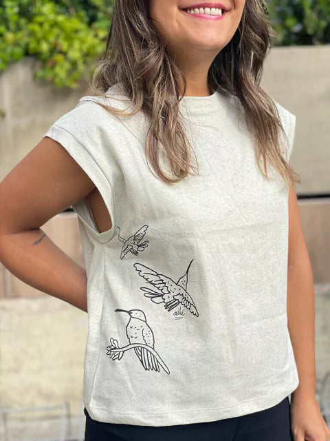 Detalle de colibríes dibujados a línea en camiseta Ailé, diseño Matu Colibrí, camiseta colibrí mujer, camiseta ilustrada aves Colombia, camiseta diseño colibrí, camiseta algodón estampada aves, ropa inspirada en fauna colombiana, camiseta colibrí hecha en Colombia comprar, dónde comprar ropa con colibríes colombianos, camiseta ilustrada fauna colombiana online, camiseta algodón colibrí diseño artesanal, marca colombiana ropa aves ilustradas. Ailé