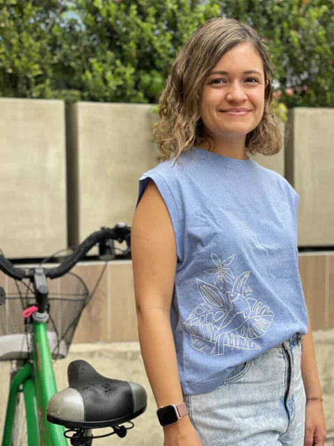 Mujer usando camiseta azul Ailé con ilustración de tucán, moda inspirada en aves tropicales de Colombia, camiseta tucán mujer, camiseta ilustrada aves tropicales, camiseta diseño tucán Colombia, camiseta algodón estampada tucán, ropa inspirada en fauna colombiana, camiseta tucán hecha en Colombia comprar, dónde comprar ropa con tucanes colombianos, camiseta ilustrada fauna tropical online, camiseta algodón tucán diseño artesanal. Ailé