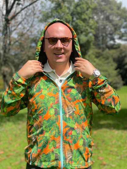 Chaqueta con capota colombiana con diseño jaguares colombianos entre hojas tropicales en naranja y verde, selva, regalo fauna silvestre Colombia, colombian wildlife waterproof jacket, colombian fauna windbreaker gift, eco friendly Colombia jacket design, chaquetas rompevientos institucionales ecológicas, chaqueta rompevientos para regalo cumpleaños, rompevientos para festival de música, chaquetas con diseños de jaguares, chaquetas antifluido de moda colombia, rompevientos liviano de tela reciclada. Ailé