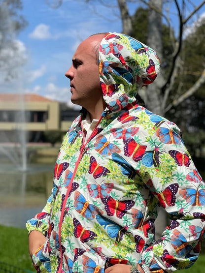 Chaqueta con capota colombiana ilustrado mariposas de Colombia entre ramas tropicales y biodiversidad, regalo colombiano fauna silvestre, souvenir mariposas Colombia, regalo sostenible, souvenir mariposas Colombia, regalo mariposas tropicales, chaqueta eco-friendly ilustrada Colombia, chaqueta rompevientos diseño colombiano, chaqueta arte colombiano, chaqueta colombiana artística, regalos para amantes del senderismo y la naturaleza, chaquetas para viajeros de aventura colombia. Ailé