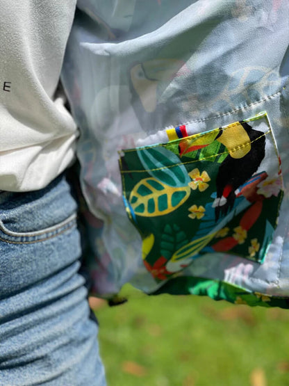 Chaqueta con bolsillo colombiano hojas de selva en verde y azul. "Colombia" tropical Colombia souvenir, eco friendly Colombia jacket design, chaquetas rompevientos institucionales ecológicas, chaqueta rompevientos para regalo de cumpleaños, rompevientos para festival de música, chaquetas con diseños de aves colombianas, chaquetas antifluido de moda colombia, rompevientos liviano de tela reciclada. Ailé