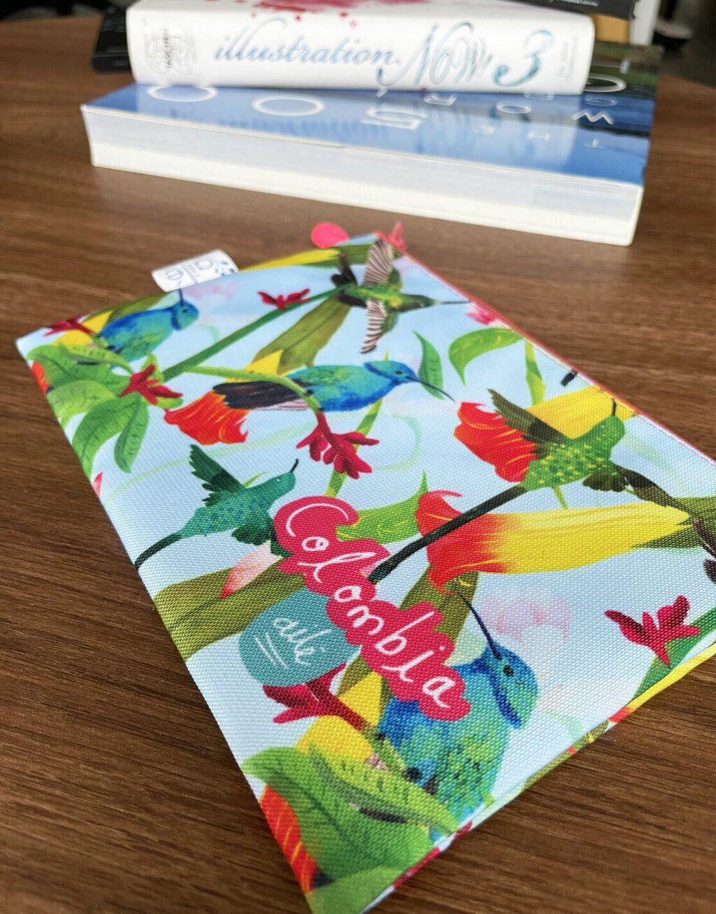 Cosmetiquera impermeable souvenir con colibríes de Colombia ilustrados, cosmetiquera tela reciclada Colombia, cosmetiquera impermeable ilustrada, souvenir viaje Colombia cosmetiquera, cosmetiquera sostenible Colombia, neceser ilustrado colombiano, regalo femenino colombiano ecológico, neceser ecológico Colombia, neceser tela reciclada impermeable, estuche cosmético colombiano, Colombian art cosmetic bag gift, bolsa cosmética ecológica Colombia. Ailé
