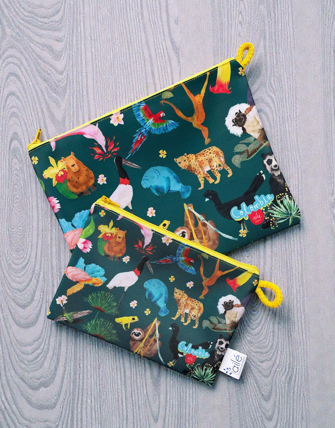 Set de cosmetiqueras souvenir con diseño de fauna silvestre de Colombia ilustrada, paujil de pico azul, oso de anteojos, frailejon, colibri, titi cabeciblanco y mono araña café — recuerdo de viaje original hecho en Colombia, souvenir colombiano. Ailé