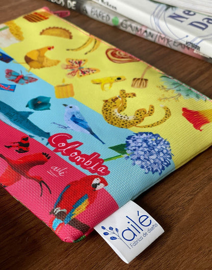 Detalle de etiqueta oficial Ailé en cosmetiquera con ilustración de Colombia —  tiburón, ballena, rana amarilla y mata de café -  producto de diseño colombiano original