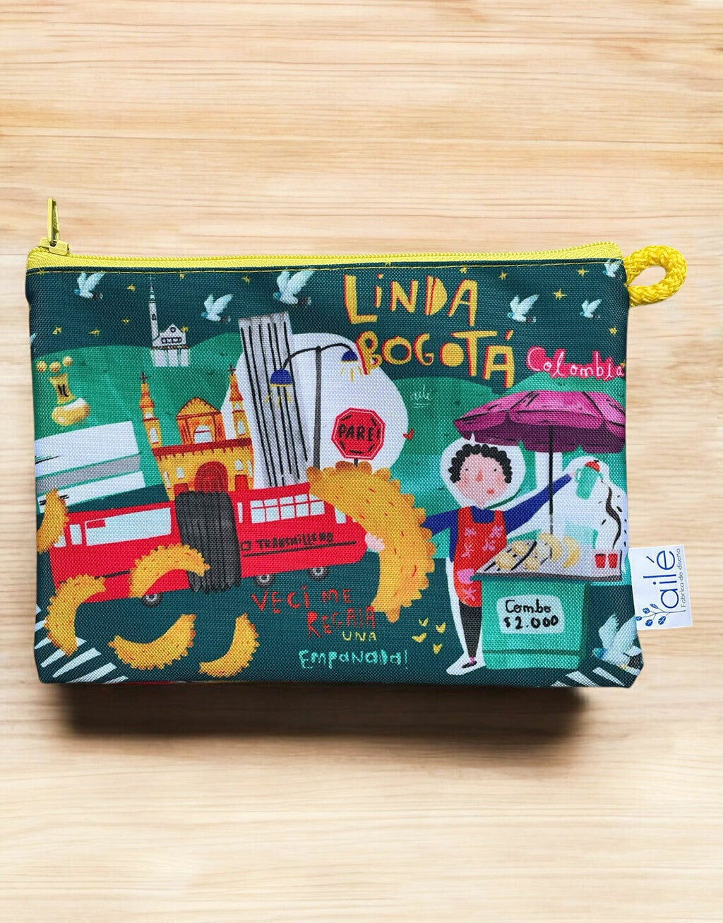 Cosmetiquera antifluido ilustrada "Linda Bogotá" con TransMilenio, empanadas y escenas urbanas — souvenir de Bogotá, hecho en Colombia, cultura Bogotana. Ailé