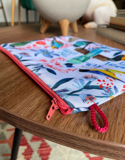 Cosmetiquera de diseño colombiano con cremallera roja — detalle de acabado e ilustración de aves, regalo sostenible, recuerdo de viaje original, hecho en Colombia. Ailé