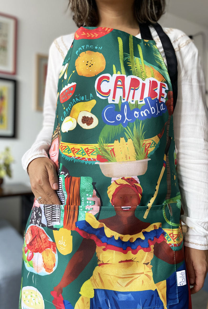 Delantal impermeable con ilustración del Caribe colombiano — palenquera, vallenato y comida típica costeña — regalo original, regala gastronomico, colombianos en el exterior y turistas, delantal ilustrado, delantal antifluido, regalo cultura colombiana, regalo original para amantes de la cocina, souvenir colombiano, recuerdo original. Ailé