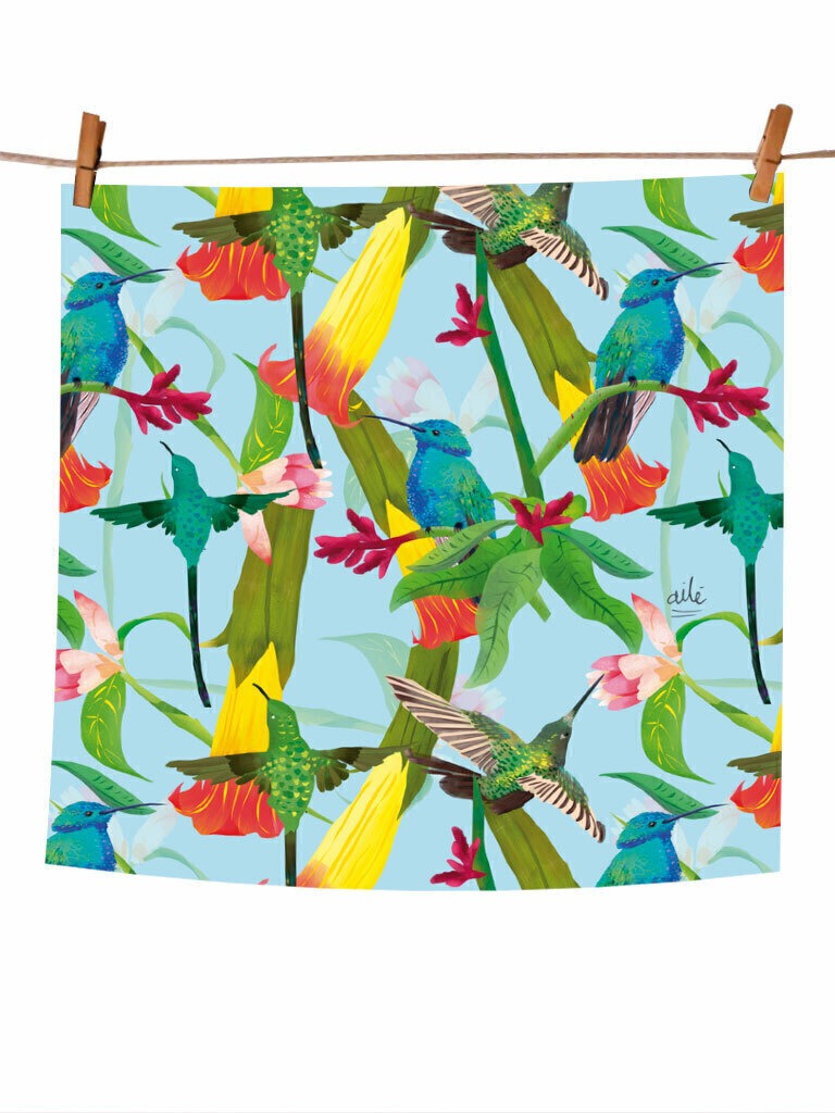 Pañoleta pequeña con ilustración "Colibrí Azul Colombia" — fondo celeste con colibríes en verde esmeralda, azul y amarillo, entre flores tropicales rojas y rosas, regalo Día de la Madre pañoleta Colombia, pañoleta grande ilustrada Colombia , pañoleta regalo mujer Colombia, pañoleta regalo Amor y Amistad Colombia, pañoleta cabello Colombia, pañoletas cuadradas grandes para hacer top souvenir Colombia pañoleta turista, regalo original mujer pañoleta Colombia. Ailé