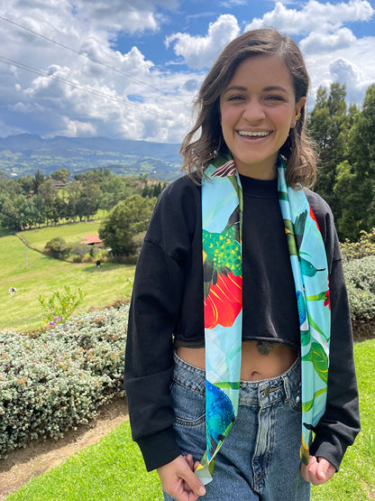 Mujer posando con pañoleta de botellas plásticas recicladas, souvenir colibrí Colombia, regalo colibríes colombianos,Colombian hummingbird souvenir, hummingbird Colombia gif, regalo accesorio colombiano ilustrado, accesorio con identidad colombiana, pañoleta playera colombiana, pañoleta amarrada como blusa mujer, complementos de moda para viajeras colombia. Ailé