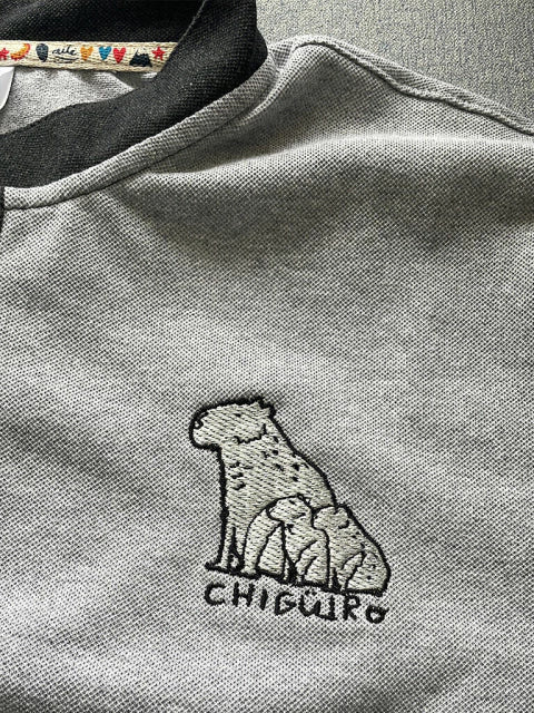 Detalle de chigüiro bordado en polo Ailé, diseño Matu Chigüiro, souvenir de los Llanos colombianos, regalo para extranjeros, chigüiro colombiano, capibara Colombia ilustrado, capybara gift, capibara souvenir Colombia, regalo con chigüiro, Colombian capybara embroidered polo, capybara animal apparel Colombia, handmade Colombian menswear wildlife gift. Ailé