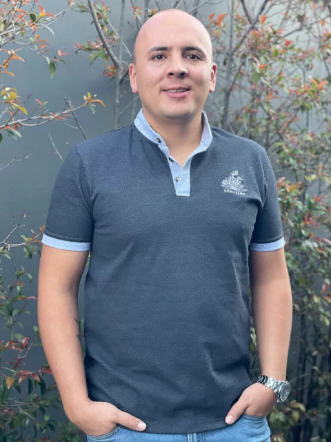 Hombre usando polo gris Ailé con frailejón bordado, moda inspirada en el páramo de Colombia, regalo colombiano original, glaciares de Colombia, frailejones Colombia, comunidades indígenas andinas Colombia,  pueblos originarios Colombia, regalo biodiversidad andina, souvenir páramo colombiano, páramo colombiano ilustrado, frailejones Colombia, frailejones andinos colombianos souvenir colombiano, Colombian páramo souvenir. Ailé