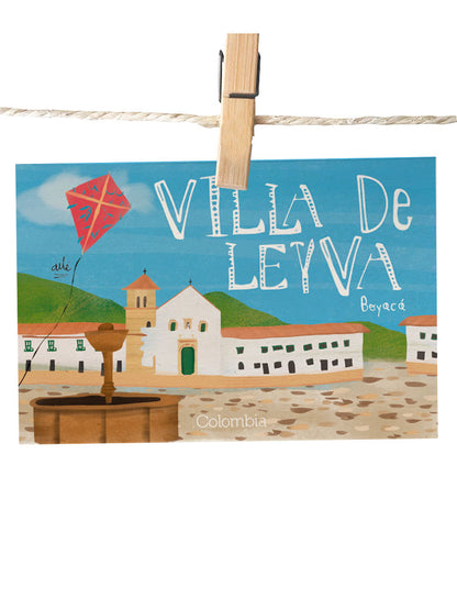 Detalle de ilustración de la plaza colonial Villa de Leyva, postal Ailé Boyacá, pueblo patrimonio de Boyacá, postal plaza mayor Villa de Leyva, ilustración iglesia colonial Boyacá, postal para enviar Colombia, sustainable paper postcard Colombia, tarjeta postal recuerdo Colombia, postal coleccionable colombiana, Colombian souvenir postcard, tarjetas postales colombianas online, postal souvenir Colombia fauna, postales souvenir hechas en Colombia. Ailé