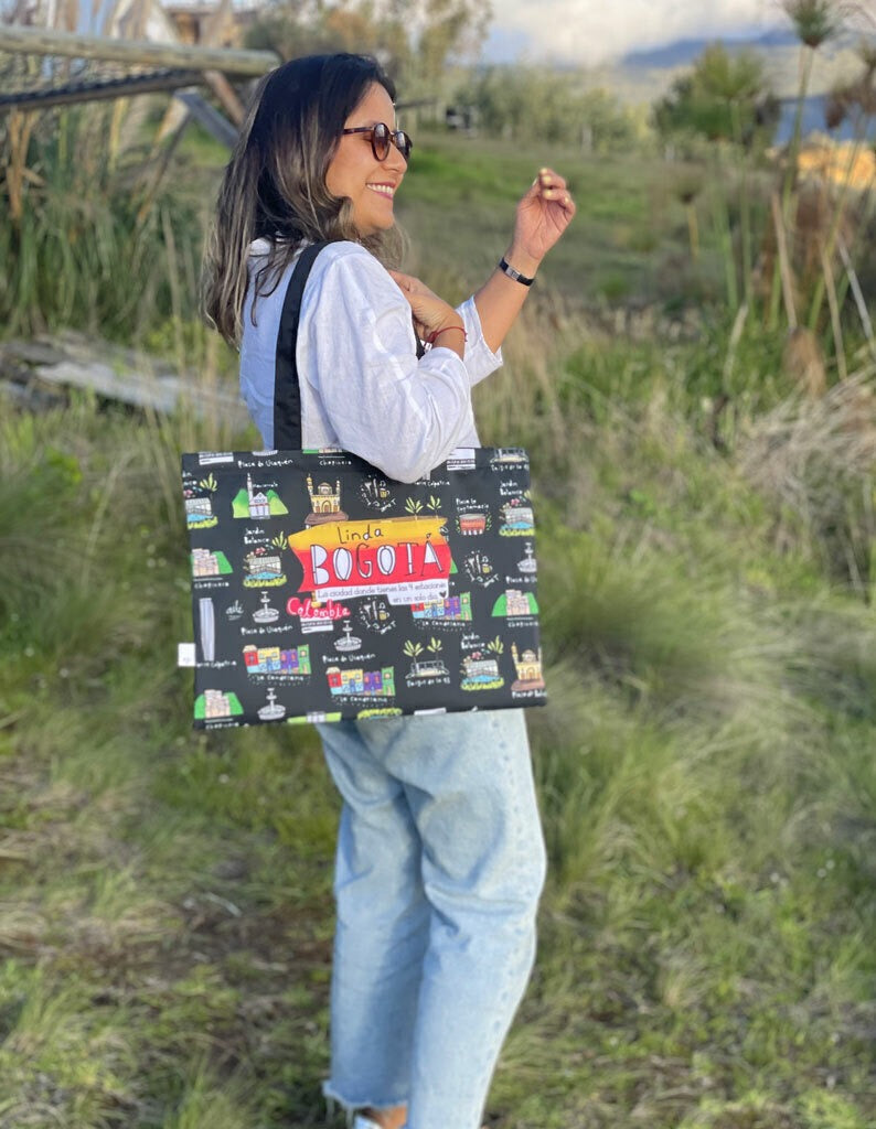 Tote bag souvenir, con diseño de los lugares icónicos de Bogotá — monumentos y barrios nombrados: "Torre Colpatria", "Plaza de Bolívar", "Parque de la 93", "La Candelaria", "Chapinero", "Plaza de Usaquén", "Jardín Botánico", "Monserrate", "Museo del Oro", "Zona T", "Plaza la Santamaria", "plaza de bolivar", comprar tote bag colombiana ecológica ilustrada, bolso compras ecológico Colombia, eco tote bag Colombia illustrated, souvenir Colombia viaje tote bag, bolso artístico Colombia regalo.Aile