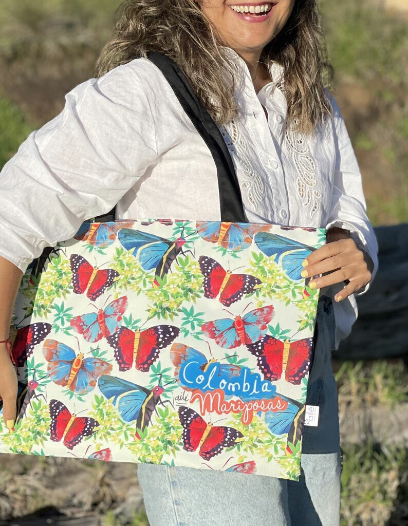 Tote bag souvenir,ilustrado con mariposas colombianas en azul y rojo, souvenir de biodiversidad, diseño original Ailé Colombia, estampado mariposas Colombia, diseño mariposas tropicales, tote bag impermeable ilustrada Colombia Ailé, detalle empresarial bolso Colombia ecológico, comprar tote bag colombiana ecológica ilustrada, bolso compras ecológico Colombia, eco tote bag Colombia illustrated.Aile
